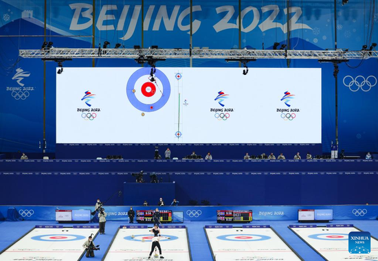 Bruce Mouat (bottom) of Great Britain competes during the curling mixed doubles bronze medal game of the Beijing 2022 Winter Olympics between Sweden and Great Britain at the National Aquatics Centre in Beijing, capital of China, Feb 8, 2022. (Photo/Xinhua)