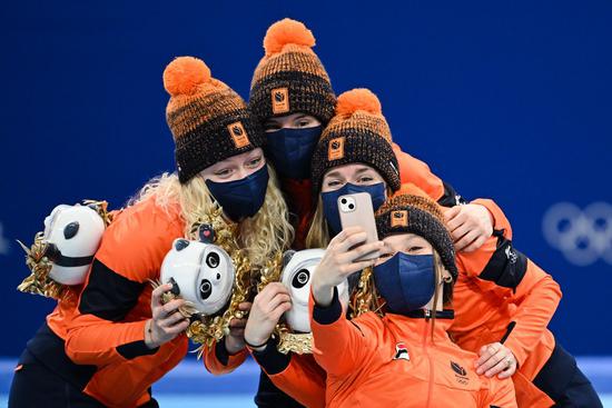 Gold medalists the Netherlands take a selfie during the flower ceremony of the women's 3,000m relay final of short track speed skating at Capital Indoor Stadium in Beijing, capital of China, Feb. 13, 2022. (Xinhua/Ju Huanzong)