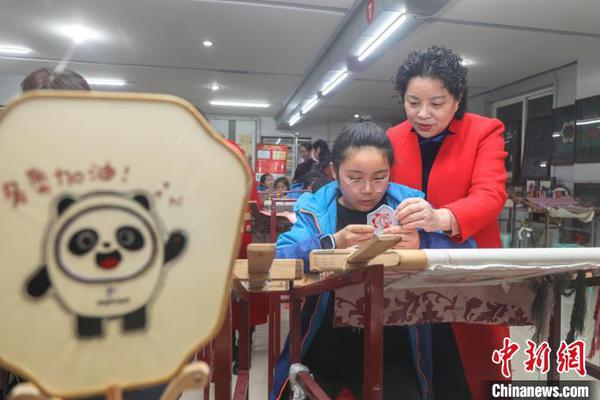Yu Zhenglian, the 8th-generation inheritor of Jiangxi Embroidery, teaches a pupil to embroider in Jiangxi. (Photo: China News Service/Liu Lixin)