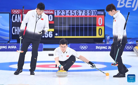 Xu Jingtao (C) of China competes during the curling men's round robin session 9 match between China and Canada of Beijing 2022 Winter Olympics at National Aquatics Centre in Beijing, capital of China, Feb. 15, 2022. (Xinhua/Huang Xiaobang)