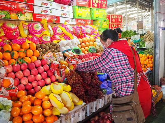 Staff organizes fruits for sale in Yaowangshan farmer's market in Lhasa, Southwest China's Tibet autonomous region. (Photo/Xinhua)