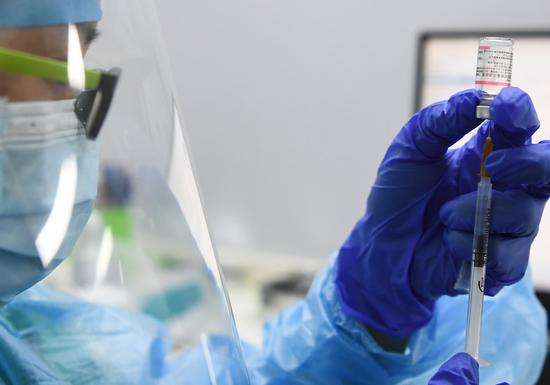 A medical worker prepares a booster shot of COVID-19 vaccine at a vaccination clinic in Fanyu District of Guangzhou City, south China's Guangdong Province, Oct. 18, 2021. (Xinhua/Deng Hua)