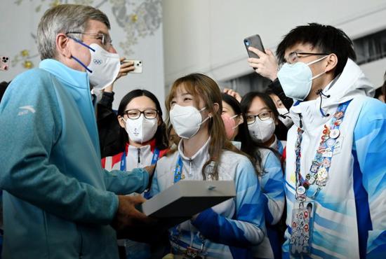 The International Olympic Committee President Thomas Bach talks with Beijing 2022 volunteers at the Main Press Center on Feb. 18, 2022.(Photo: Xinhua/Li Yibo)
