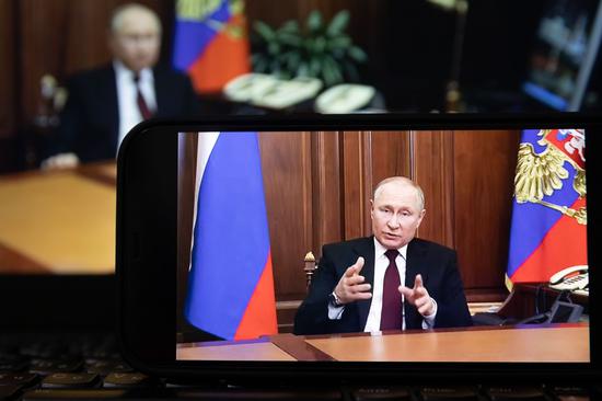 Photo taken on Feb. 21, 2022 shows a screen displaying Russian President Vladimir Putin speaking during a televised address to the nation in Moscow, Russia. (Xinhua/Bai Xueqi)