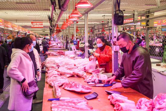 Residents buy pork at a wholesale market in Hohhot, north China's Inner Mongolia Autonomous Region, Oct. 24, 2021. (Xinhua/Peng Yuan)