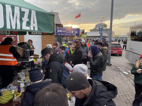 Photo taken with a mobile phone shows people queuing for hot water in Medyka, Poland, Feb. 26, 2022. (Xinhua/Chen Chen)