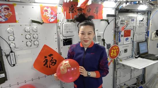 Taikonaut Wang Yaping, dressed in festive costumes, wishes children across China 
