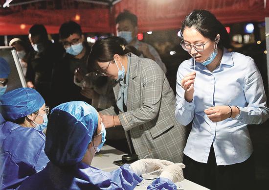 A resident of Hangzhou, Zhejiang province, takes a free COVID-19 antigen self-test in Hangzhou, Zhejiang province, on Tuesday. (ZHANG XIANGRONG/FOR CHINA DAILY)