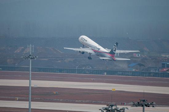 An air freighter flies over the Ezhou Huahu Airport in Ezhou, central China's Hubei Province, March 19, 2022. (Xinhua/Xiao Yijiu)