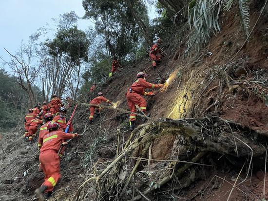 Photo taken with a mobile phone shows rescuers searching for the black boxes at a plane crash site in Tengxian County, south China's Guangxi Zhuang Autonomous Region, March 22, 2022.  (Xinhua/Zhou Hua)