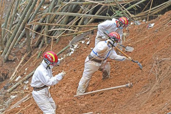 Rescuers secured by safety ropes conduct search and rescue work at the plane crash site in Tengxian County, south China's Guangxi Zhuang Autonomous Region, March 25, 2022. (Xinhua/Zhou Hua)