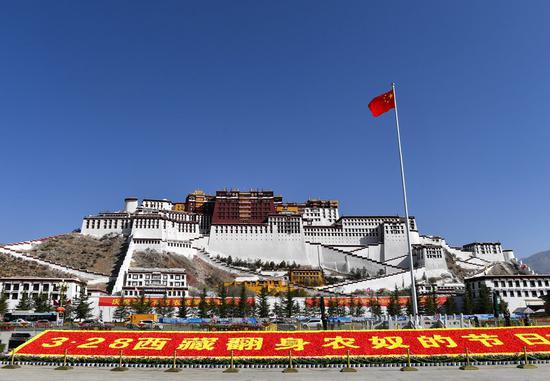 A flag-raising ceremony is held to celebrate the Serfs' Emancipation Day at the square in front of the Potala Palace in Lhasa, capital of southwest China's Tibet Autonomous Region, March 28, 2022. (Xinhua/Jigme Dorge)
