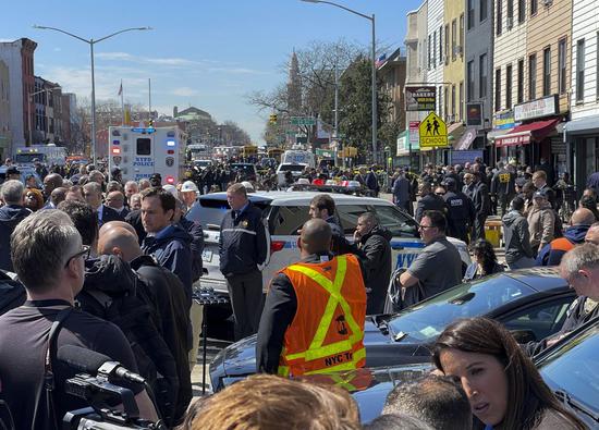 Photo taken with a mobile phone shows police and investigators working at a nearby street after a shooting took place at a subway station in Brooklyn, New York, the United States, on April 12, 2022. (Xinhua/Zhang Mocheng)