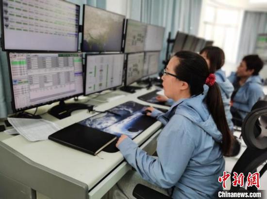 Engineers at the Miyun Station working on the first track data reception of the satellite. (Photo/ China News Service) 