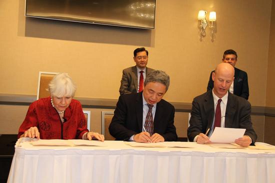 Sarah Lande (1st L) and Wanxiang America Corporation President Ni Pin (C, Front) sign the agreement of the 