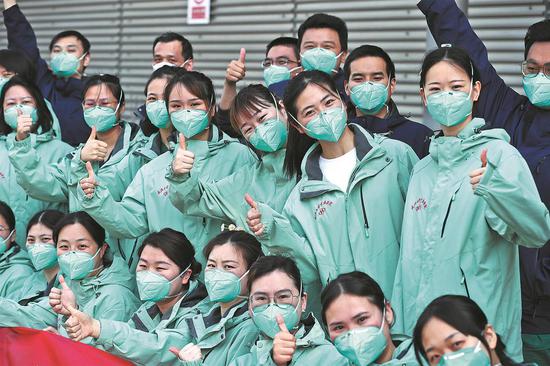 Medical workers from Wuhan, Hubei province, pose for a group photo at the makeshift hospital in the Shanghai New International Expo Center on Wednesday. The medics, mostly young people, were sent to Shanghai to help in the battle against its latest COVID-19 outbreak. (ZHU XINGXIN/CHINA DAILY)