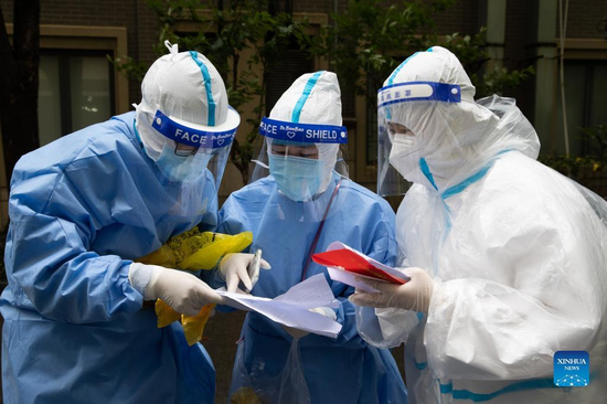 Medical workers check residents' information with a community staff member in East China's Shanghai, April 26, 2022. (Photo/Xinhua)