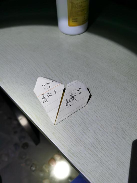A heart-shaped note with Chinese characters 