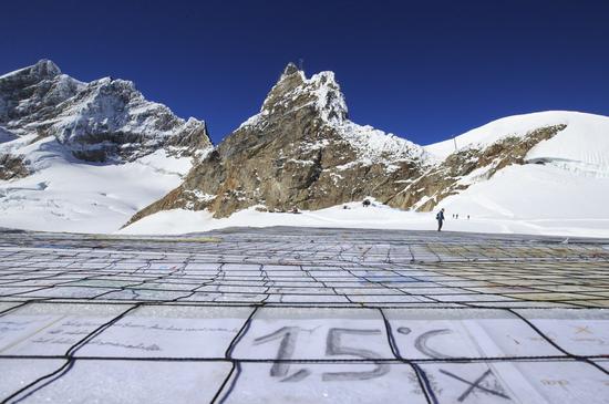 A gigantic postcard with the writing of 1.5 degrees Celsius is seen on the Aletsch glacier under Jungfraujoch in Switzerland, on Nov. 16, 2018.  (Xinhua/Xu Jinquan)