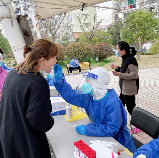 Ono Himiko (in a blue protective suit) takes a sample from a woman for nucleic acid test. (Photo provided by Ono Himiko)