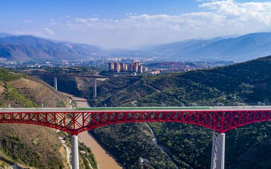 Foto udara menunjukkan kereta api melintasi jembatan utama Yuanjiang di atas Sungai Yuanjiang di Provinsi Yunnan, China barat daya, 18 Januari 2022. (Xinhua/Chen Xinbo)