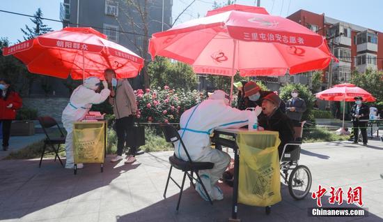 A medical worker takes nucleic acid testing for a citizen in Chaoyang District in Beijing, May 15, 2022. (Photo/China News Service)