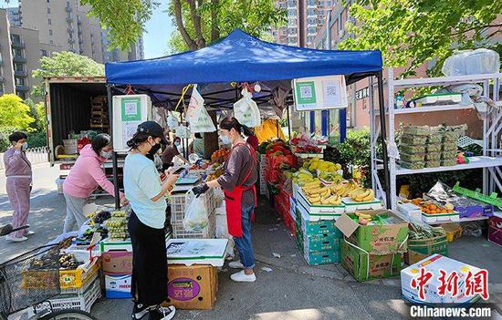 Residents buy fruits from a supply van in Chaoyang District, Beijing, May 16, 2022. (Photo/China News Service)