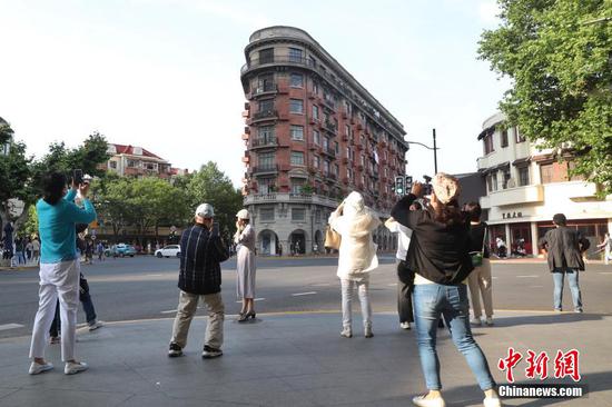 People take photos in front of Wukang Mansion in Shanghai, May 21, 2022. (Phoo/China News Service)