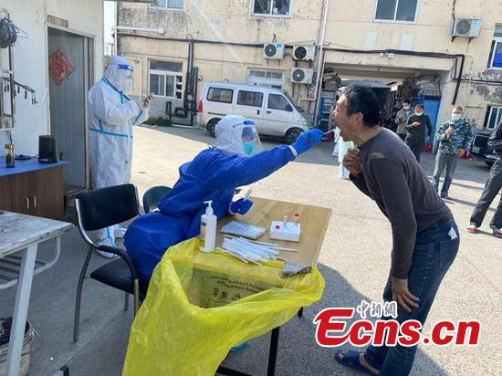 Terasaki Makoto takes a swab sample from a man for COVID-19 nucleic acid test at a community in Shanghai. (Provided by the interviewee)