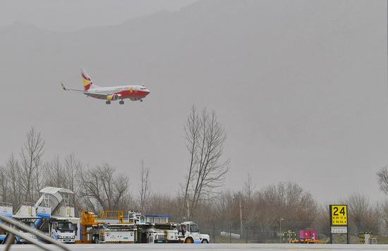 An aircraft flies over an airport in southwest China's Tibet Autonomous Region, Dec. 30, 2021. (Xinhua/Zhang Rufeng)