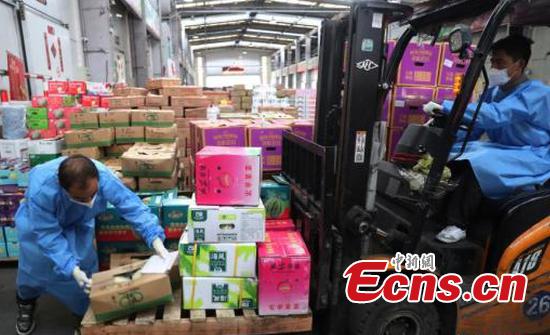 Workers distribute goods at an agricultural products Center in the western suburbs of Shanghai, on May 24, 2022. (Photo/China News Service)
