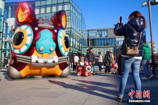Tiger-themed sculptures attract people in front of a mall in Beijing, February 1,2022. (Photo/China News Service) 