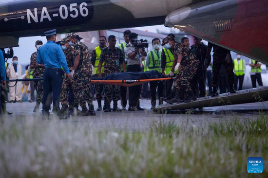 A rescue team of Nepal Army carry the body of a plane crash victim at the airport in Kathmandu, Nepal, May 30, 2022. Twenty-one bodies have been recovered from the crash site of a Nepali passenger plane in a remote hilly area in Nepal's Mustang district, a local government official said on Monday. Ten bodies have been sent to Kathmandu in a helicopter, the official said. (Photo: Xinhua/Sulav Shrestha)