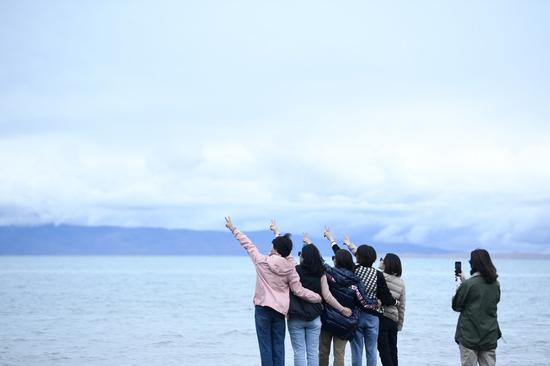 Tourists pose for photos in Qinghai Lake scenic area in northwest China's Qinghai Province, Sept. 15, 2021. (Xinhua/Zhang Long)