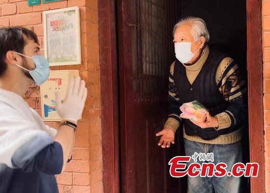 Evgeniy Matveev (L) hands cookies and candies to the elders (Provided by the interviewee)