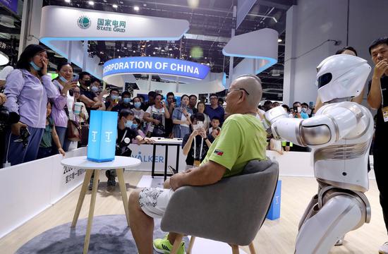 A visitor is massaged by a service robot at the 2021 World Artificial Intelligence Conference (WAIC) in east China's Shanghai, July 8, 2021. (Xinhua/Fang Zhe)