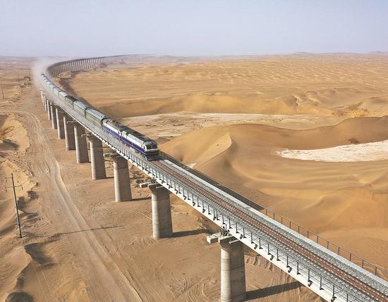 A train goes on a test run on the Hotan-Ruoqiang railway on March 11. The 825-kilometer line will open to the public on Thursday, marking the completion of the world's first railway loop circling a desert. (Photo by WEN XINGHUA/FOR CHINA DAILY)