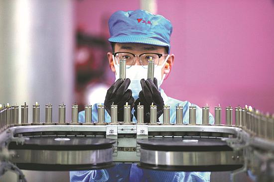 A worker at an automated workshop in Huzhou, Zhejiang province, checks lithium battery products in a factory on Wednesday. The nation's economy showed signs of recovery in May, according to data from the National Bureau of Statistics. (Photo/XINHUA)