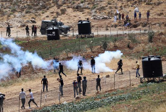 Palestinian protesters clash with Israeli soldiers and members of Israeli border police following a protest against the expansion of Jewish settlements in the West Bank village of Qaryut, south of Nablus, on June 24, 2022. (Photo by Ayman Nobani/Xinhua)