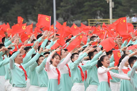 Young people wave national flags and Party flags to celebrate the centenary of the Communist Party of China at Tian'anmen Square in Beijing in 2021.（Photo/Xinhua）
