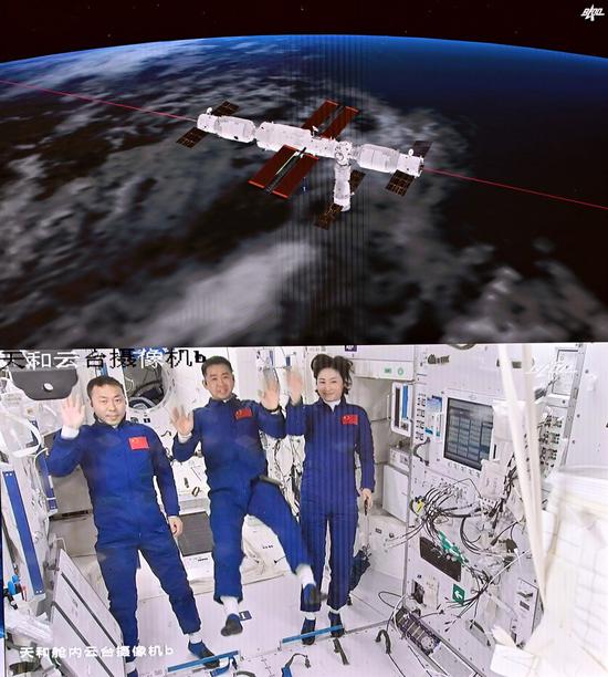Screen image captured at Beijing Aerospace Control Center on June 5, 2022 shows three Chinese taikonauts, Chen Dong (C), Liu Yang (R) and Cai Xuzhe, waving after entering the space station core module Tianhe. (Xinhua/Li Xin)