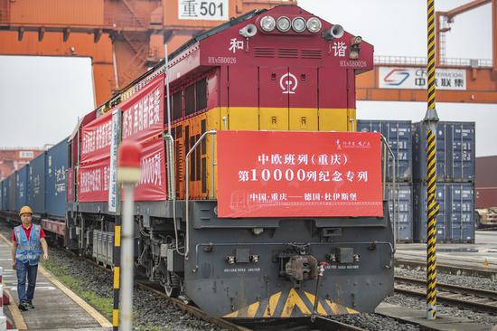 A cargo train marking the 10,000th trip made by China-Europe freight trains operated by the China-Europe Railway Express (Chongqing), waits for departure at Tuanjie Village Central Railway Station in Chongqing, southwest China, June 23, 2022. (Xinhua/Huang Wei)

