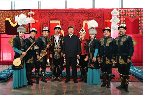 Chinese President Xi Jinping, also general secretary of the Communist Party of China Central Committee and chairman of the Central Military Commission, poses for photos with the performers of the Manas, which has been inscribed as an intangible cultural heritage, while visiting the Museum of the Xinjiang Uygur Autonomous Region in the city of Urumqi, capital of northwest China's Xinjiang Uygur Autonomous Region, July 13, 2022. (Xinhua/Xie Huanchi)