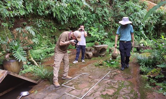 Experts observe and measure the dinosaur tracks discovered at a restaurant in Leshan, Southwest China's Sichuan Province on July 16, 2022. (Photo/Courtesy of Xing Lida)