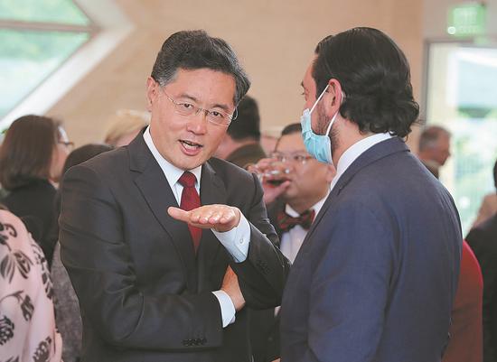 Chinese Ambassador to the United States Qin Gang (left) talks with Daniel Legarda, vice-minister of foreign trade of Ecuador, at a reception at the Chinese embassy in Washington on Tuesday evening marking the 95th anniversary of the founding of China's People's Liberation Army. (ZHAO HUANXIN/CHINA DAILY)