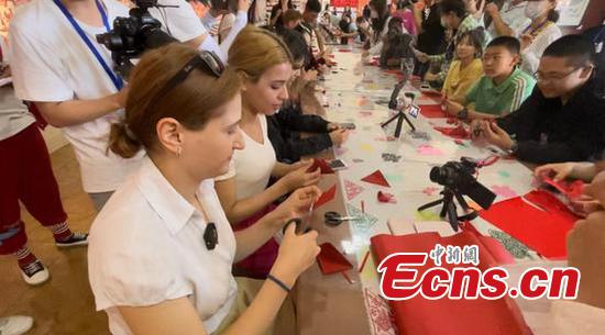 Foreign internet celebrities learn papercutting from Zhao Meling, July 27, 2022 (Photo: Ecns/Zhang Dongfang)