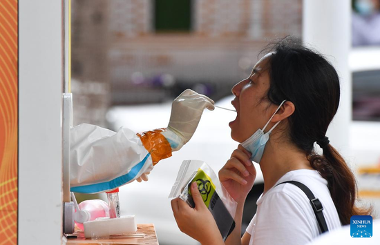A resident receives a nucleic acid test at a testing site in Longhua district of Haikou, South China's Hainan province, Aug 7, 2022. (PHOTO/XINHUA)