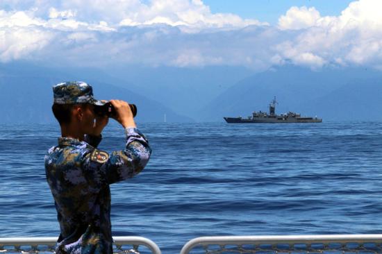 A soldier looks through binoculars during combat exercises and training of the navy of the Eastern Theater Command of the Chinese People's Liberation Army in the waters around the Taiwan island, Aug 5, 2022. (Photo/Xinhua)