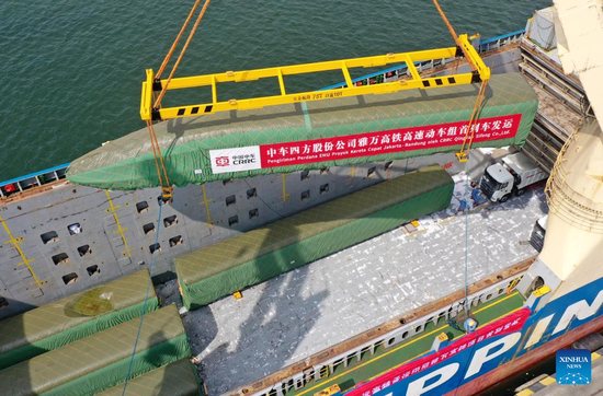 Aerial photo taken on Aug. 18, 2022 shows a high-speed electric passenger train, customized for the Jakarta-Bandung high-speed railway, being loaded on a vessel in Qingdao Port of east China's Shandong province. A set of passenger trains and a inspection train will be transported to Indonesia, marking important progress in the construction of the railway, a landmark project under the Belt and Road Initiative. (Photo by Jiang Chao/Xinhua)