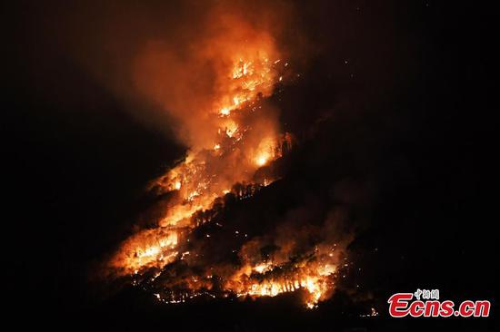 A massive fire burns on a mountain in Fuling district of Chongqing, Aug. 19, 2022. Firefighters battle to contain the blaze. (Photo: China News Service/Chen Chao)

